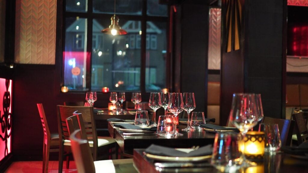 Restaurant tables set for guests with polished glasses